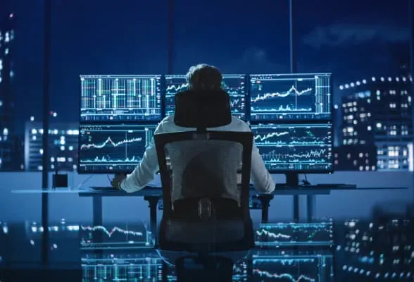Financial professional monitoring multiple screens, illustrating StoneX Pro's turnkey FX solutions and streamlined liquidity services.