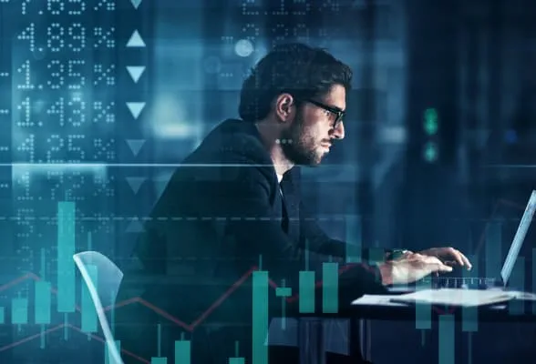 Financial professional analyzing data on a laptop, representing StoneX Pro's liquidity solutions and tools for managing market exposure.