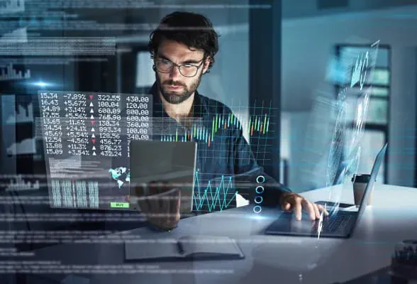 Trader working with multiple devices, representing StoneX Pro's flexible introducing broker and white-label solutions for trading infrastructure.