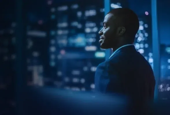 Professional looking out over a city at night, symbolizing StoneX Pro's comprehensive FX solutions and streamlined onboarding process.