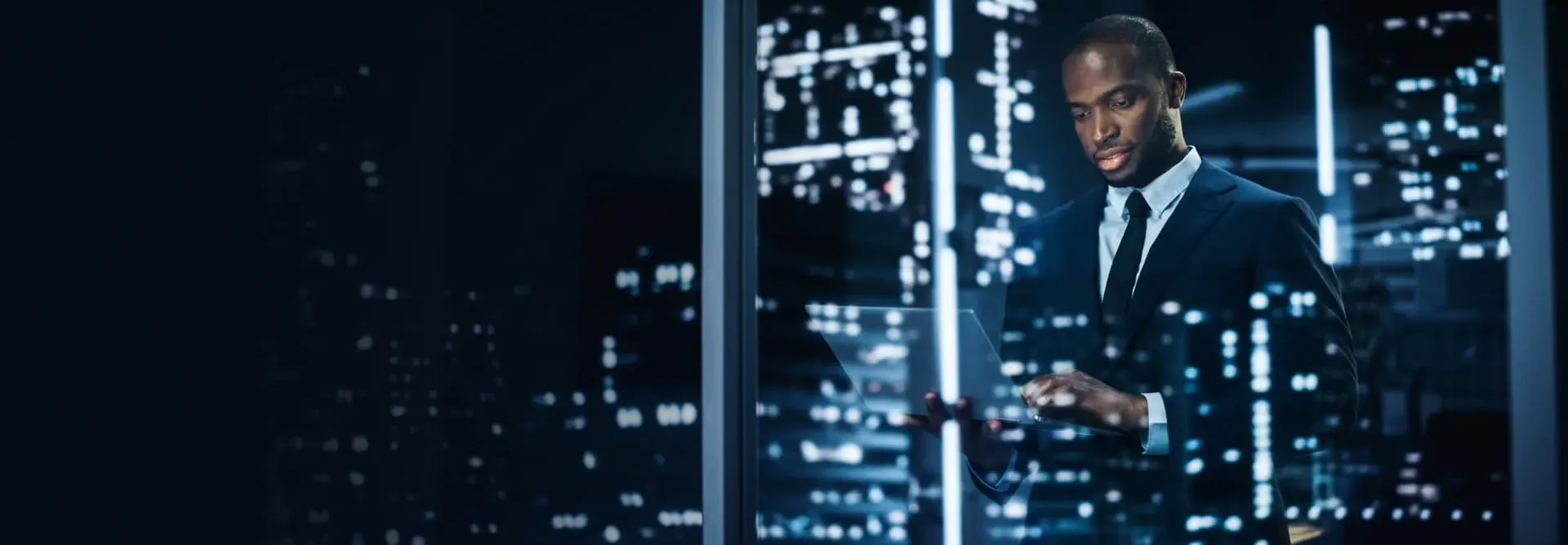 Professional using a tablet at night, representing the integration of expertise, technology, and liquidity in StoneX Pro's trading solutions.