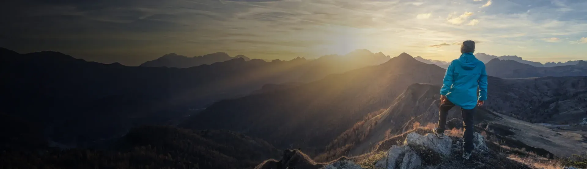 Individual overlooking a mountain landscape, symbolizing financial independence and strategic wealth management with StoneX