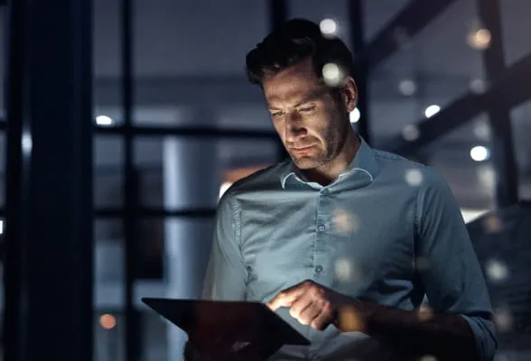 Professional reviewing documents on a tablet, representing StoneX Wealth Management's comprehensive disclosure and compliance information