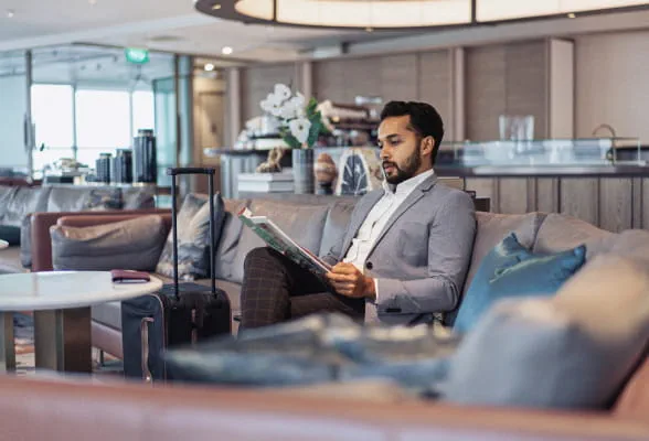 Man reading in a lounge, highlighting StoneX Wealth Management's personalized financial services for international private clients