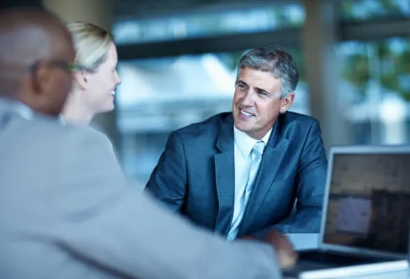 Professionals in conversation, showcasing StoneX Wealth Management's self-directed wealth solutions for independent clients
