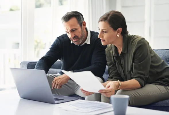 Two people reviewing financial documents, highlighting StoneX Wealth Management's advisory solutions, products, and support services for advisors