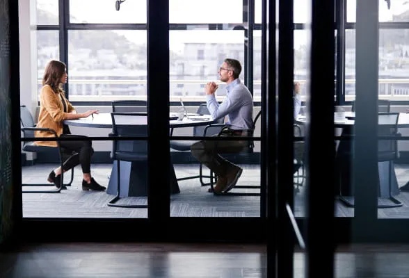 Two professionals in a meeting room, illustrating StoneX Wealth Management's dedicated transition support for financial advisors switching firms