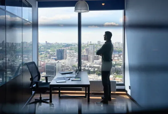 Professional standing in an office, highlighting StoneX Wealth Management's support and resources for financial institutions and family offices